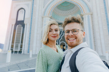 Happy tourist lover couple takes selfie photo against mosque of NurSultan Astana Kazakhstan city...