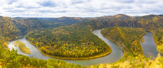 Colorful autumn panoramic landscape with loop on meandering river among mountains in Siberia. Mana is a river in Krasnoyarsk Krai, Russia, right tributary of the Yenisey. Loop on Mana river. Top view