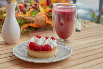 Aesthetic healthy autumn lunch - pink strawberry smoothie and french tart on the wooden table
