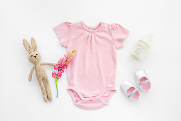 Baby girl bodysuit with toys and accessories, flat lay