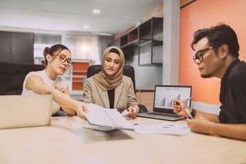 business muslim and asian woman and man have meeting. diversity people with asian woman and man and hijab person having a conversation about project at workplace. in conference room people is debate