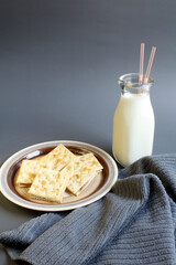 An after school snack of peanut butter on crackers with a mini bottle of milk. Space for text.