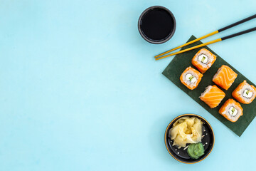 Sushi rolls set with salmon eco served on green papper plate, top view