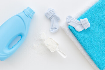 White washing powder with towels and a laundry conditioner bottle