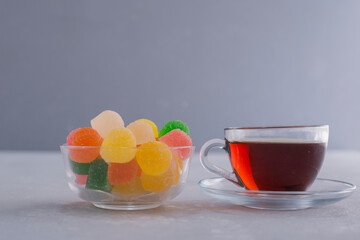 A cup of colorful marmelades with a glass of earl grey tea