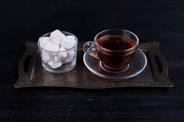 White marshmallows with a cup of tea in a metallic platter