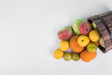 Summer fruits mix out of a wooden bucket, top view