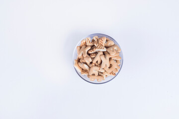 Obraz premium Vanilla crackers in letter shape in a glass cup, top view