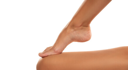 Beautiful well-groomed women's legs and foot close-up on a white isolated background, The concept of foot skin care.