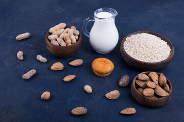 Dry fruits and ingredients with a jar of milk with a cupcake aside