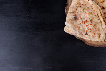 Caucasian kutab with stuffings on a piece of wood isolated on black