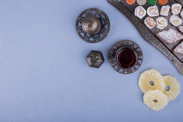 Pastry board with dry fruits and a glass of tea