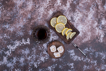 A glass of tea with lokum and sliced lemon