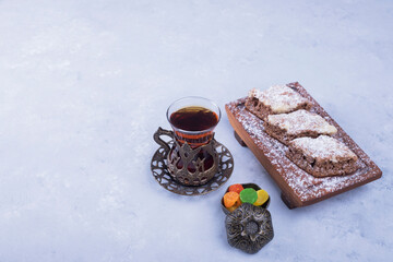 Caucasian tea set with metallic tea glass and pastry platter isolated on blue background