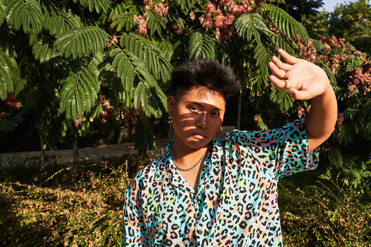 Filipino non binary person protecting face from sun