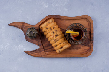 Rollcake served with earl grey tea in a wooden platter , top view