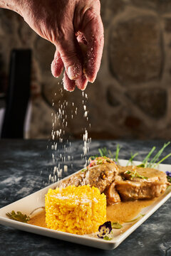 Crop cook garnishing rice on plate