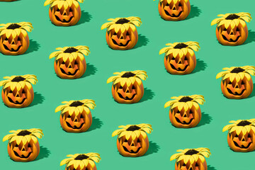Autumn , halloween 2022. Halloween pumpkin with yellow sunflower  on green  background. Minimal festive pattern composition.