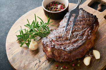 Steaks. Grilled New York Steak with spices rosemary and pepper on black marble board on gray background. Top view. Mock up.