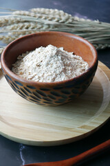 natural oats flakes in a bowl on black background 