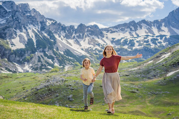 Fototapeta na wymiar Family of tourists mom and son in Mountain lake landscape on Durmitor mountain in Montenegro beautiful Durmitor National park with lake glacier and reflecting mountain Portrait of a disgruntled girl