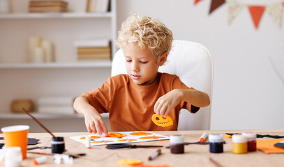Cute child  boy    making Halloween home decorations