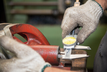 Close up scene the operator measuring inside diameter casting parts by dial Vernier caliper.