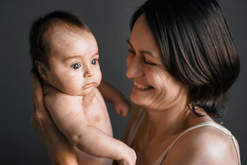 Mom, mummy, young mother with little baby daughter. Breast-feeding. Mum kissing,hugging child. Newborn cute happy girl smiling in woman hands. Family happiness. Age parents, parenting, motherhood