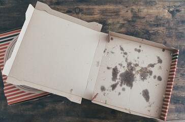 top down view of empty stained cardboard pizza delivery boxes on rustic wooden table