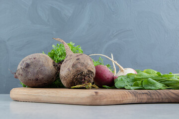 Beetroot , radish and parsley on board , on the marble background