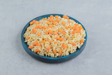 Carrot rice in the wooden plate , on the marble background
