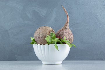 Fresh parsley and radishes in the bowl , on the marble background