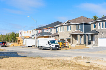 Semi-detached houses in construction in a housing development on a clear autumn day