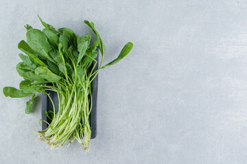 A tray of fresh watercress , on the marble background