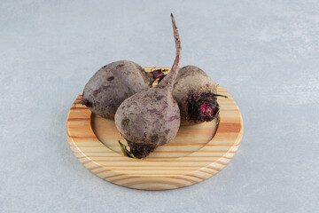 Toothsome radishes in the wooden plate , on the marble background