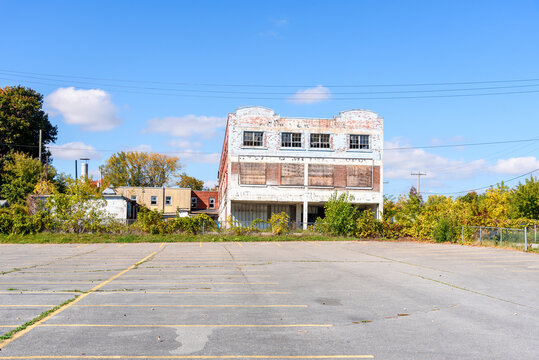 Empty parking lot bordered by old run-down buildings on a clear autumn day