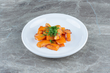 A plate of sliced carrots, on the marble background