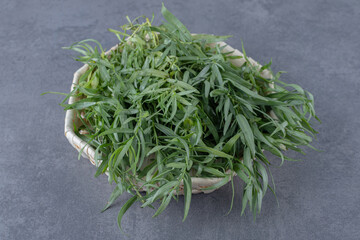 A bowl of fresh tarragon, on the marble background