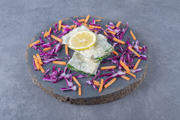 Sliced lemon, red cabbage and carrot with folded gutab , on the marble background