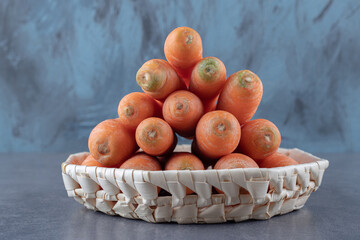 Delectable carrots in the bowl , on the marble background