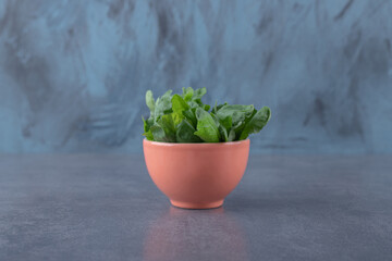 Fresh watercress in cup, on the marble background