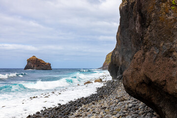 Waves roll on the rocky coast of northern Madeira