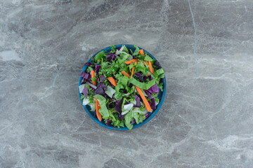 Tasty sliced vegetables in a bowl , on the marble background