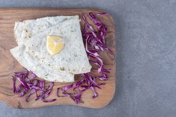Gutabs and red cabbage on the board , on the marble background