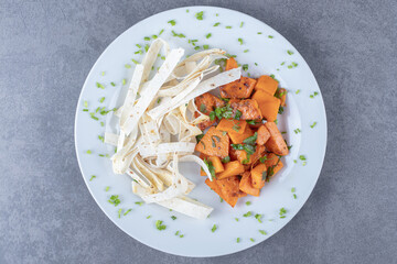 Sliced lavash and baked carrot in plate , on the marble background