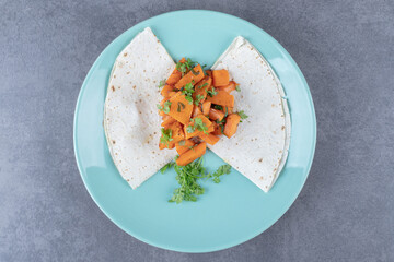 Lavash and baked carrot in plate , on the marble background