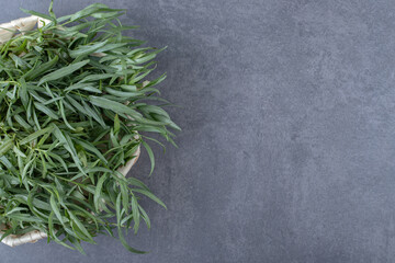 A bowl of fresh tarragon, on the marble background