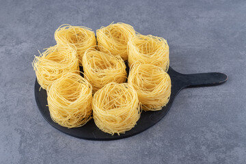 Raw egg noodles on black board
