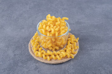 Raw dry macaroni in glass bowl
