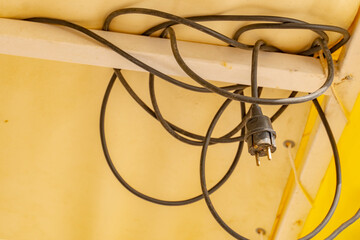 Black tangled electrical cable connecting lights and other electrical appliances.